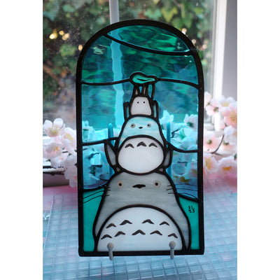 Stained glass panel with Totoro characters from Studio Ghibli, stacked atop of one another.