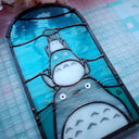 Stained glass panel with Totoro characters from Studio Ghibli, stacked atop of one another.
