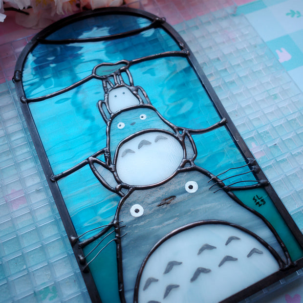 Stained glass panel with Totoro characters from Studio Ghibli, stacked atop of one another.