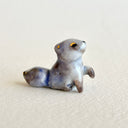 Ceramic figurine of a small tanuki raccoon with golden eyelids