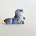 Ceramic figurine of a small tanuki raccoon with golden eyelids