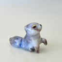 Ceramic figurine of a small tanuki raccoon with golden eyelids