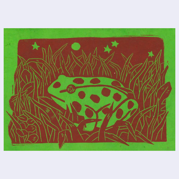 Red ink linocut print on green paper of a frog sitting in tall grass with stars overhead.