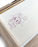 Back view of a framed artwork with a white canvas backing and a doodle.