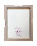Back view of a framed artwork with a white canvas backing and a doodle.