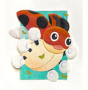 A colorful handmade paper artwork with collage details, of a flying cartoon ladybug displayed on a textured white background.