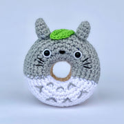 A crocheted donut fashioned to look like Totoro, with a green leaf atop his head.