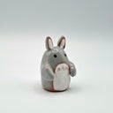 Small gray ceramic Totoro figurine on a white background