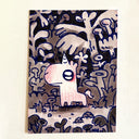 Artwork featuring a whimsical cartoon unicorn surrounded by stylized plants, shown hanging on a light beige wall.