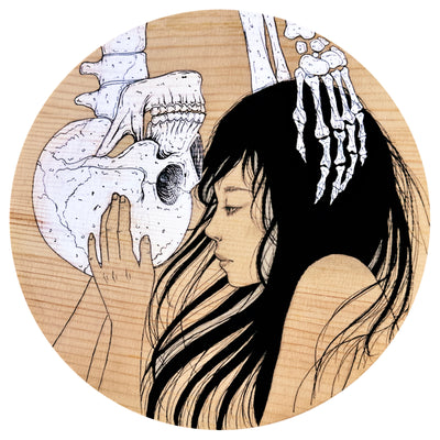 Illustration on circular wooden panel of a woman with long, wispy hair looking at an upside down skeleton with both of them caressing one another's face.