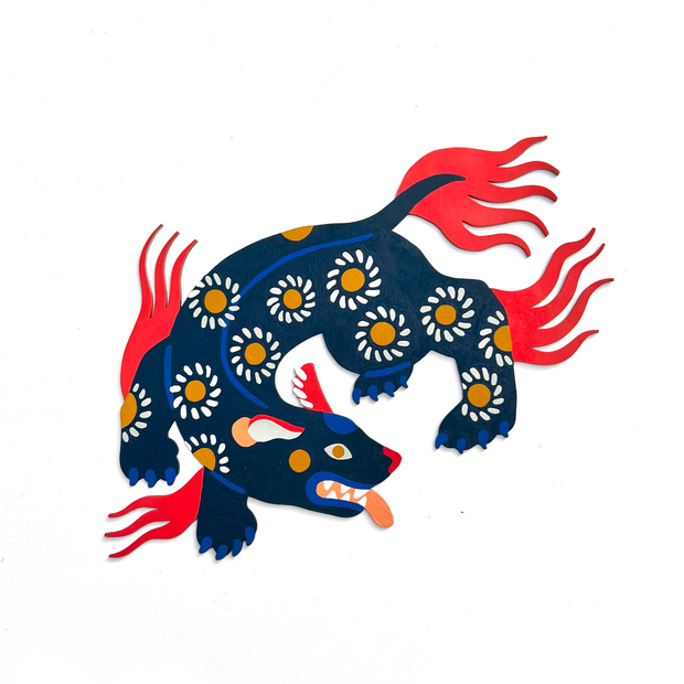 Die cut, brightly painted wooden sculpture of a folklore style dog, with a daisy pattern on its body, which contorts to show movement. It has bright red hair coming out of its tail and back of its legs and arms.