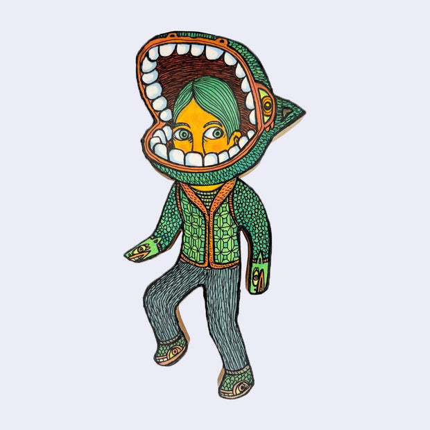 Illustration made with many lines, giving it the feel of a folk art woodcut on a die cut wood panel of a character with knit sweater and pants. Around his head is a large, open monster mouth with many teeth.
