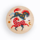 Round wooden panel with a painting of 2 horses on it, both with wild manes and polka dot patternings. One is red and one is navy blue.