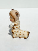 Caterpillar with the face of a Kewpie baby and coloring of a Siamese cat. It holds a bottle of milk in its hands.
