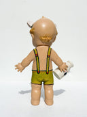 Vintage-style Kepwie doll with green overalls holding a bottle of milk and smoking a cigarette on a white background