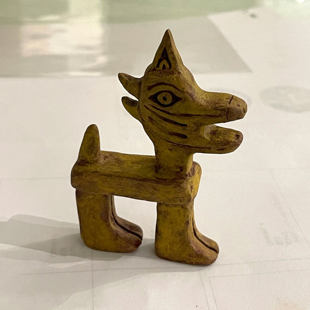 Tan sculpture of of an ancient looking horse or cat.