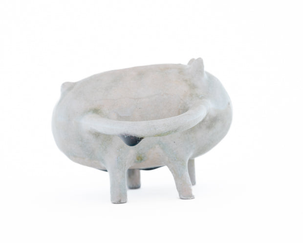 Ceramic sculpture of a gray character with small eyes and ears and standing on all fours. It has 2 mug handle like shapes coming out of its sides.