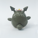 Ceramic figurine of a stylized Totoro with a flower on its head against a white background