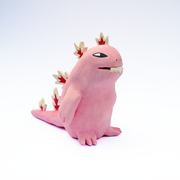 Ceramic sculpture of a chubby, cute cartoonish dinosaur with white and red spikes.