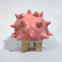 Ceramic sculpture of a cartoon style hedgehog with pink spikes and cute eyes and rosy cheeks.