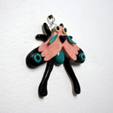 Ceramic wall hanging sculpture of a winged bug in cute pastel coloring with black moth-like wing accents.