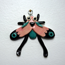 Ceramic wall hanging sculpture of a winged bug in cute pastel coloring with black moth-like wing accents.
