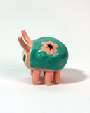 Small ceramic sculpture of a cute pink and teal bug.