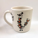 White mug with illustrated motifs of nature and birds.