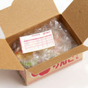 Open cardboard box with bubble wrap and a pink invoice on a white background