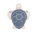 Wooden figure of a gray and white turtle with a rounded shell, flat belly and cute cartoon frown.