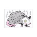 A hand-drawn illustration of an opossum on a white rectangular paper, with the letters 'AAA AHH' above it and a small signature 'KC26' in the lower left. The opossum is drawn with gray fur, a pink tail, a black-and-white face, and a yellow eye.
