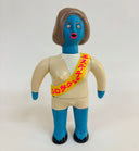 Toy figure with blue skin, brown hair, and a yellow sash on a white background