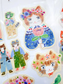 Set of decorative stickers featuring cartoon cats with floral accessories on a white background.