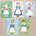 Five illustrated post cards featuring animals in traditional outfits on a wooden surface.