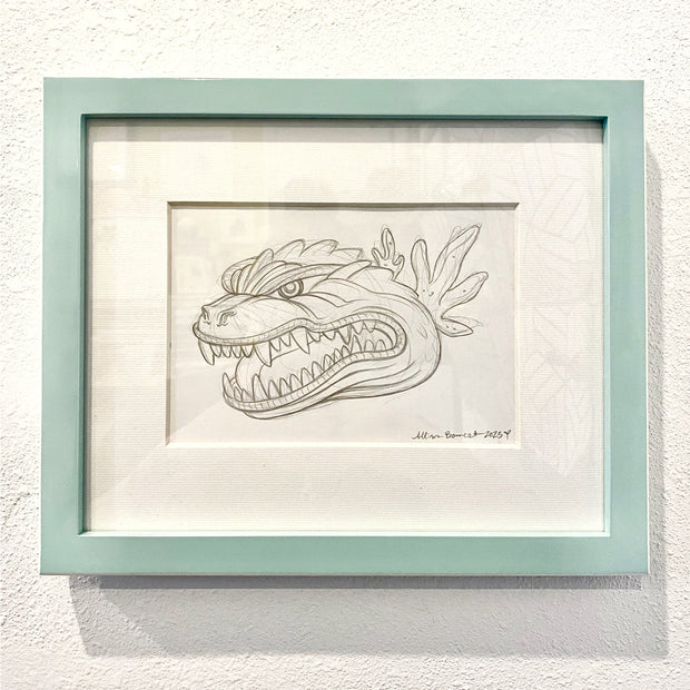 Refined graphite sketch drawing of a Godzilla head, with an open mouth and teeth showing. It's matted and in a mint colored frame.