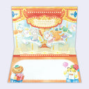 Open greeting card with pop-up interior of animals riding a carousel.