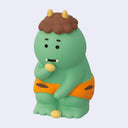 Green cartoon-like creature with orange shorts on a light gray background