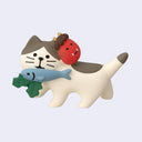 Figure of a cat with a fish + holly in its mouth and a oni mask on its head against a light blue background