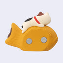 Magnet shaped and designed as a small cat laying atop of a very large fish shaped pastry (taiyaki). Backside.