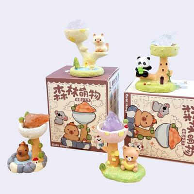 Set of small animal figurines on bases with colorful landscapes and one crystal for each.