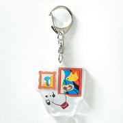 Keychain with cartoon character and framed images on a white background