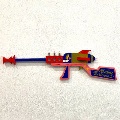 Colorful toy gun labeled 'Atomic Stinger' on a white background