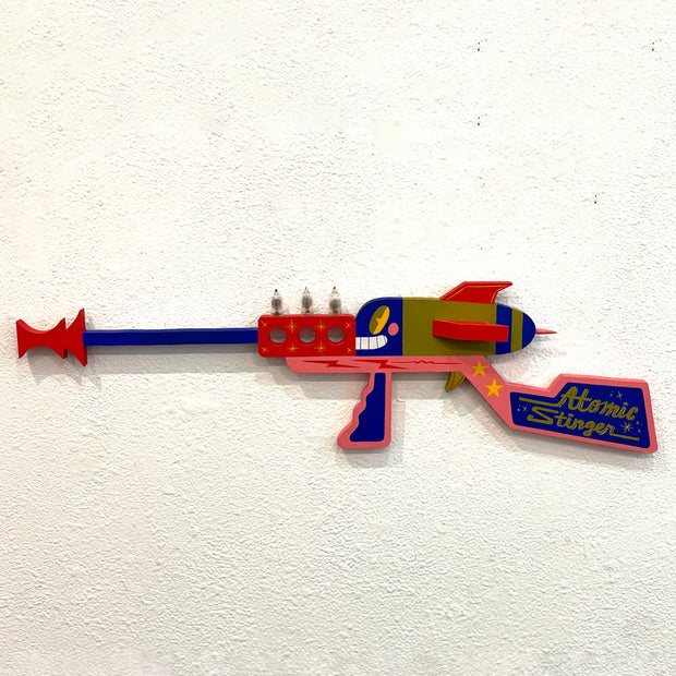 Colorful toy gun labeled 'Atomic Stinger' on a white background