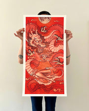 Illustration of a woman with bare legs, sitting with her knees pulled towards her. A large dragon wraps around itself behind her. Half of a moon hangs overhead. Piece is monochromatic in red. Print is shown being held by the artist.