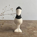 Decorative figure of a shoebill bird, standing on a wooden surface with a gray background