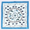A square white scarf featuring a detailed equestrian theme. The design includes a blue border, a central brown ring with horses and riders, and smaller equestrian illustrations along the outer border.