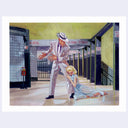 Man in a suit and hat looking down while a woman in a dress kneels beside him in a subway station.