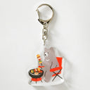 Keychain with bear design cooking on a grill on a white background
