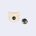 Back view of a ceramic pin shaped like a bear's head with a metal pin and matching backing.