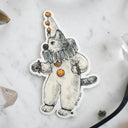 Die cut white sticker of a cartoon cat dressed up in a clown costume.